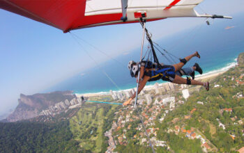 salto de asa delta com Morro do Pão de Açúçar à esquerda e mar do Rio de Janeiro e céu azul