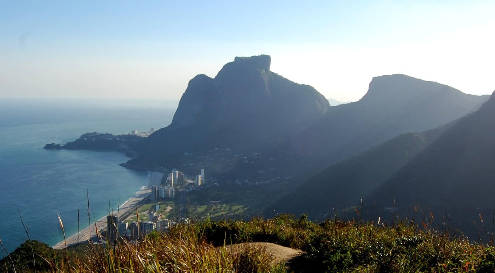 Muitas dúvidas me impedem de voar Nascer do sol visto de cima de um morro com vista para a pedra da Gávea e a Pedra Bonita no Rio de Janeiro, praia à esquerda da imagem