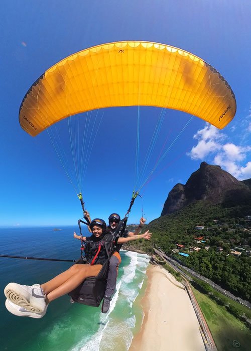 Voo de parapente no Rio de Janeiro com a Pedra da Gávea ao fundo.